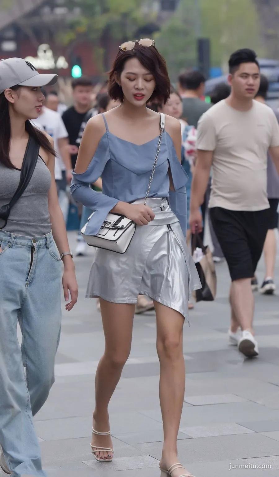 路人街拍身材修长的吊带露肩姑娘，短裙穿出白皙长腿