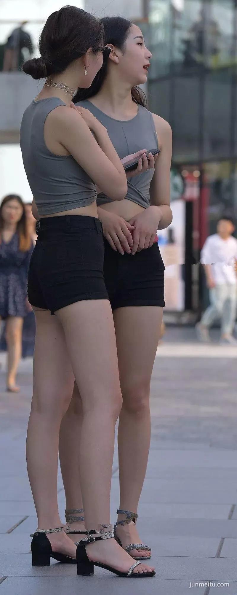 街拍高挑热裤浑圆挺翘雪白如玉修长双腿露脐饱满姐妹花