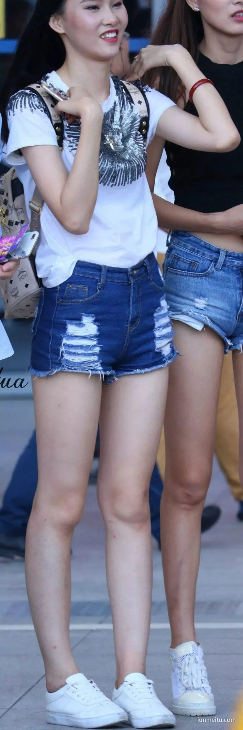 街拍美女穿着牛仔热裤秀出一双超细竹竿腿